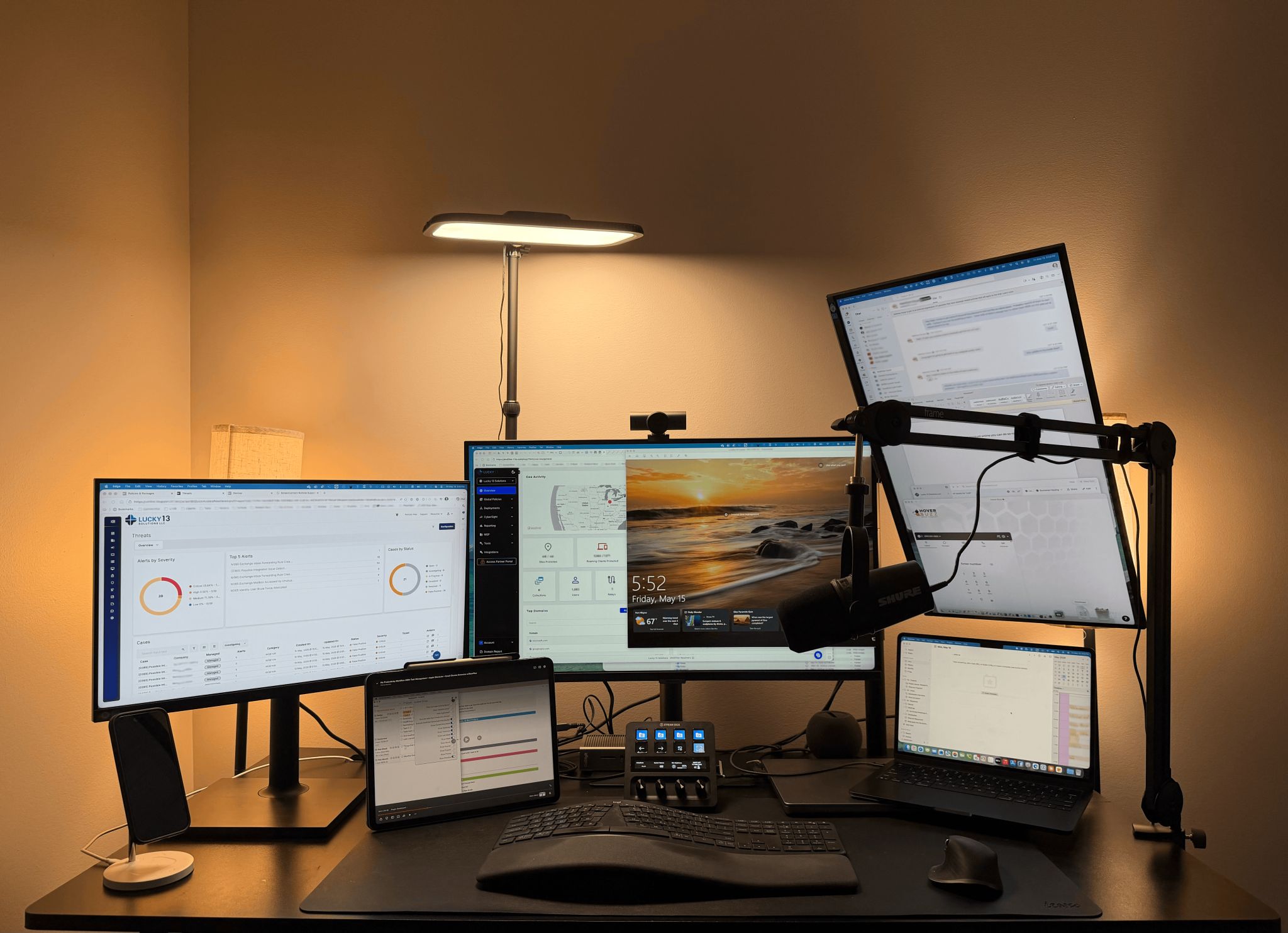Multi-monitor home office desk setup with a Shure microphone, Stream Deck, iPad, and MacBook — John Shelton&rsquo;s current work environment